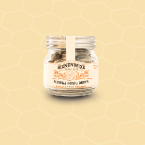 Bienenwixe Manuka Honig Drops mit Eukalyptus und Orange in einem Glasbehälter.