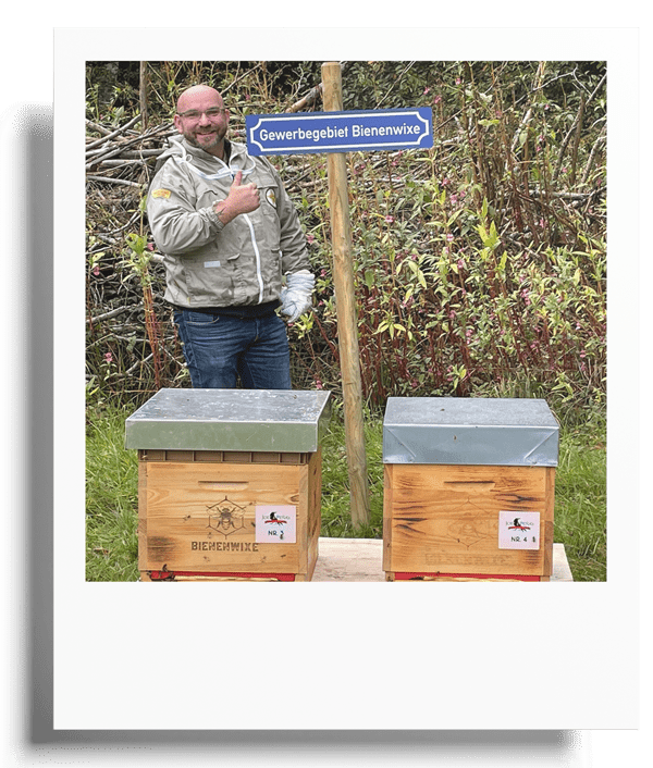 Mario Tenspolde Gründer von Bienenwixe bei zwei Bienenstöcken im „Gewerbegebiet Bienenwixe“.