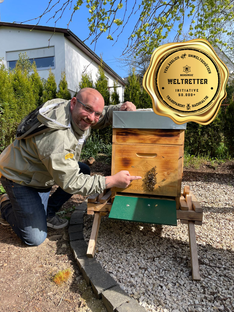 Mario Tenspolde, der Gründer von Bienenwixe bei einem Bienenstock mit dem Weltretter-Siegel.