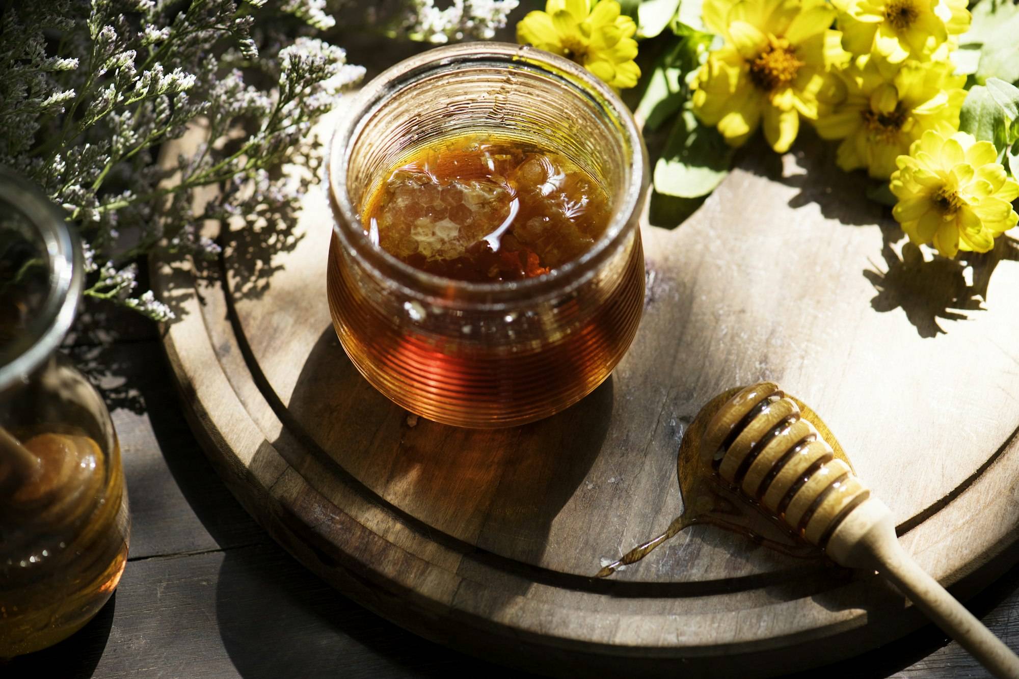 Ein Glas Bienenwixe Manuka Honig mit goldener, cremiger Textur und elegantem Etikett. Echter Manuka Honig mit hohem MGO-Gehalt.